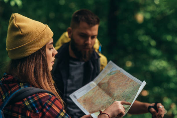 istock Couple of hikers using map to find another path while hiking in the nature 1323400268
