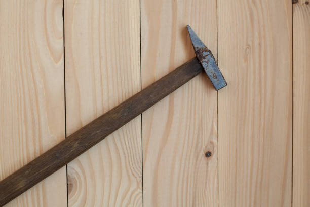istock Hammer with a long wooden handle on a light wooden background. 1323406150