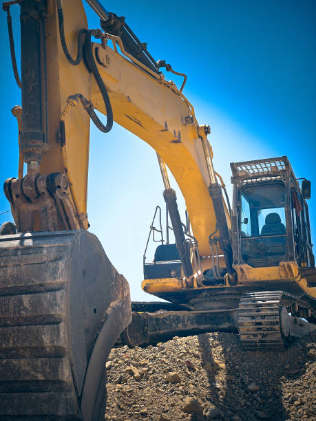 vista de baixo ângulo da escavadeira no canteiro de obras - caterpillar truck - fotografias e filmes do acervo