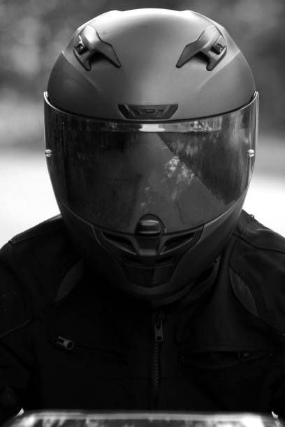 istock Man Wearing Motorcycle Helmet Looking at Camera Black & White 1323413903