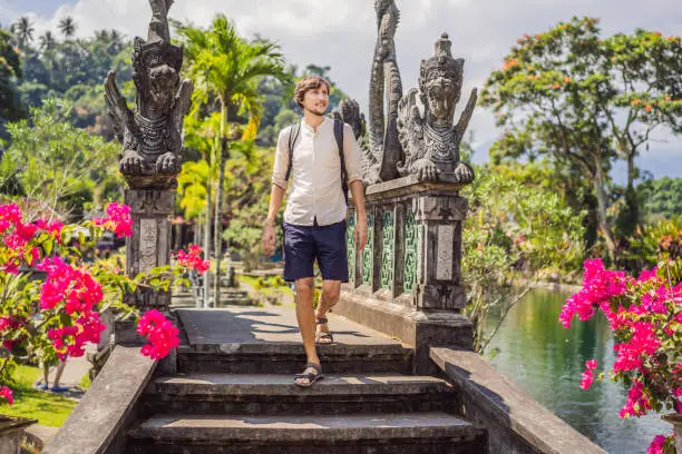 Photo of Young man tourist in Taman Tirtagangga, Water palace, Water park, Bali Indonesia