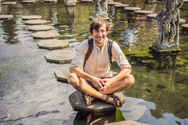 Photo of Young man tourist in Taman Tirtagangga, Water palace, Water park, Bali Indonesia