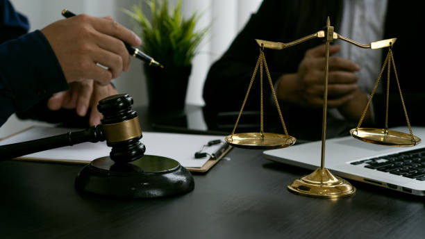 lawyer, legal counsel meeting with businessman with judge's hammer and scales of justice lay in front with laptop on office table. - declaring bankrupcy imagens e fotografias de stock