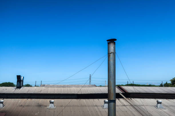 Chimneys in an old factory against a blue sky background
