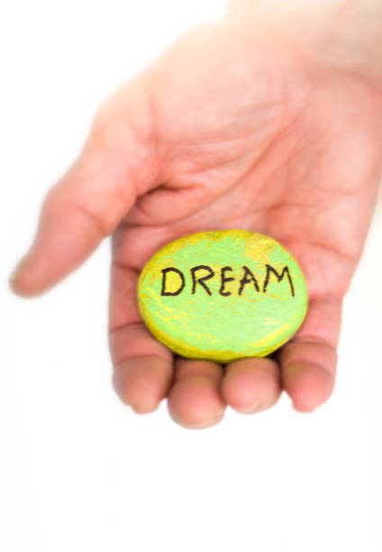 istock Man's Palm Offering Painted River Rock Reading 