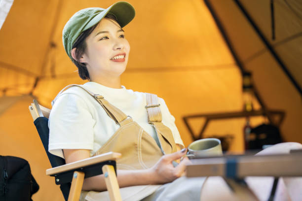 istock Young woman relaxing at a campsite 1323423818