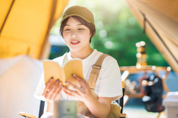 istock Young woman reading a book 1323424640