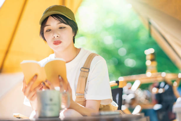 istock Young woman reading a book 1323424717