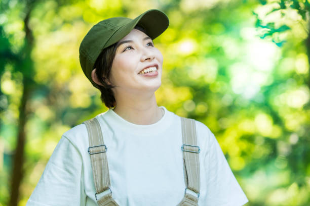 istock Woman looking up at the trees in the forest 1323425566