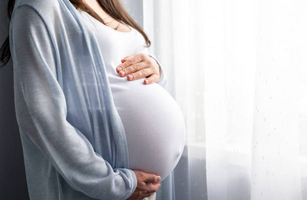 gezonde zwangerschap. zijaanzicht zwangere vrouw met grote buik geavanceerde zwangerschap in handen. banner copyspace voor tekst. elegante moeder die baby wacht - buik stockfoto's en -beelden