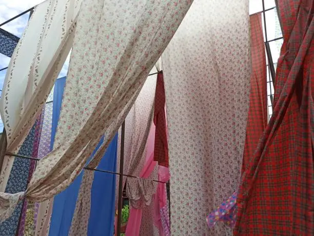 Colourful pattern fabric hanging on traditional dye dryer at Asia village banner