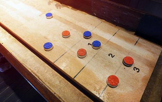 shuffle board the vintage bar board game with red and blue scoring on the board