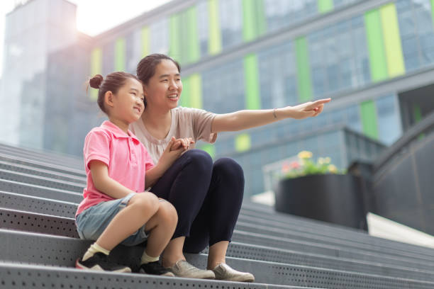 istock Little Girl and Mother Sitting Steps 1323437885