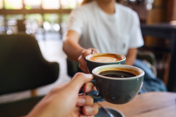 istock a man and a woman clinking coffee mugs in cafe 1323438067
