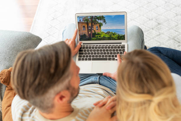 istock Couple sitting on the sofa at home and using laptop 1323439001