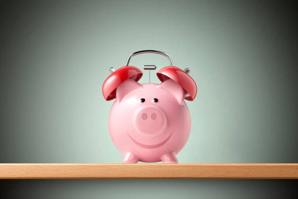 Alarm clock piggy bank on shelf
