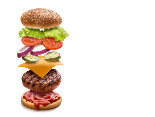istock Burger layered ingredients as explosion flying open bun isolated on white 1323442478