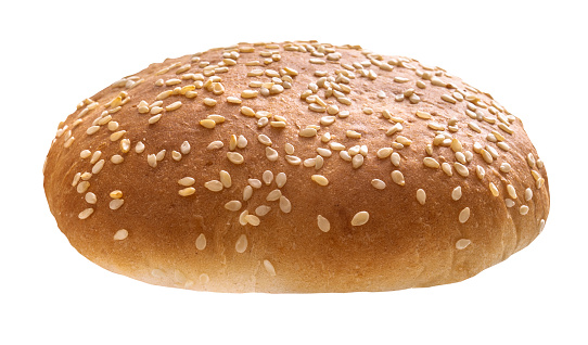 Burger bun bread with sesame seeds half cut top half isolated on white background