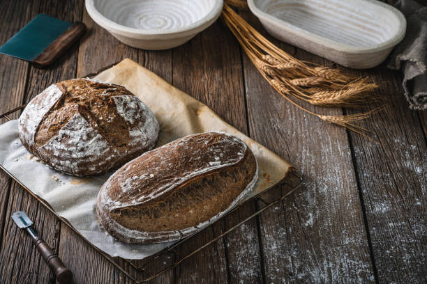 istock Sourdough bread loaf and Banneton basket in bakery on wooden rustic table 1323443402