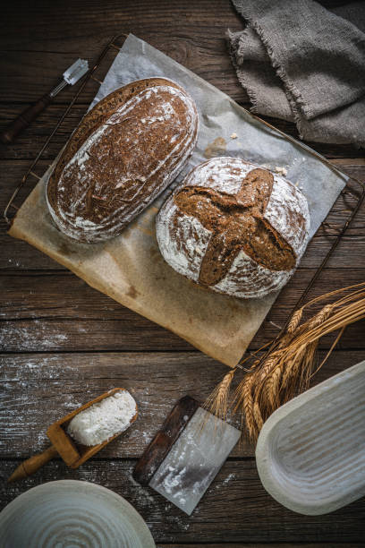istock Sourdough bread loaf and Banneton basket in bakery on wooden rustic table 1323443417