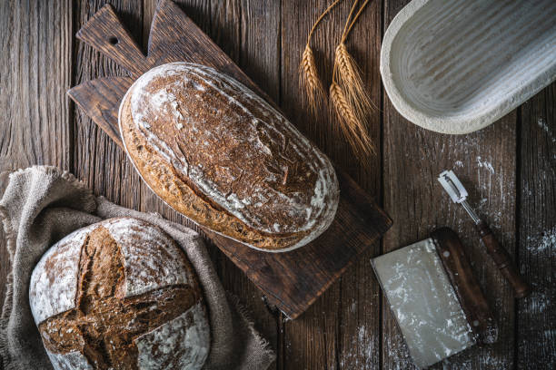 istock Sourdough bread loaf and Banneton basket in bakery on wooden rustic table 1323443449