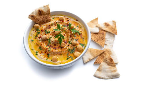 Chickpea hummus bowl closeup with pita flatbread dipping isolated on white