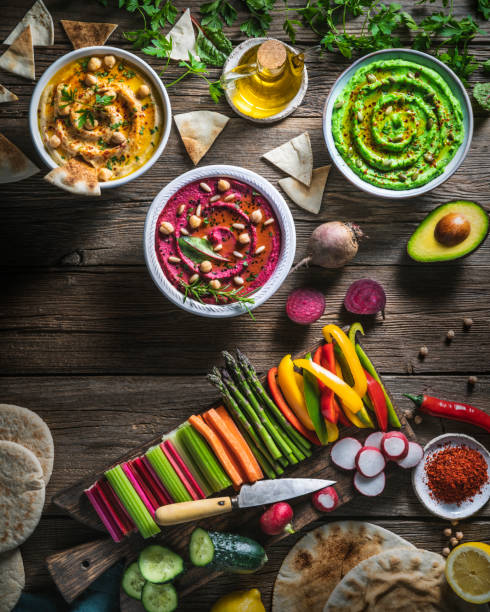 istock Hummus Three bowl of chickpeas, avocado and beetroot with cut vegetables for dip on rustic wood table 1323444395