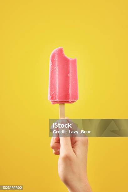Bitten Red Frozen Fruit Ice Cream Popsicle On Yellow Background Stock Photo - Download Image Now