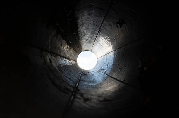 abstract black tunnel made with round pipe. concept of exit or endless. a light in the end of a tunnel. - end of round imagens e fotografias de stock