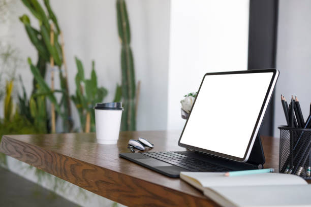 istock Computer tablet, notebook, coffee cup and pencil holder on wooden table. 1323444541