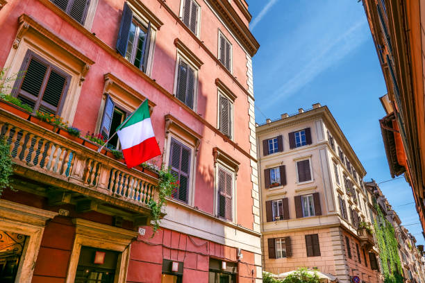 eine malerische straße mit italienischer flagge im stadtteil monti im historischen herzen roms - paving stone cobblestone road old stock-fotos und bilder