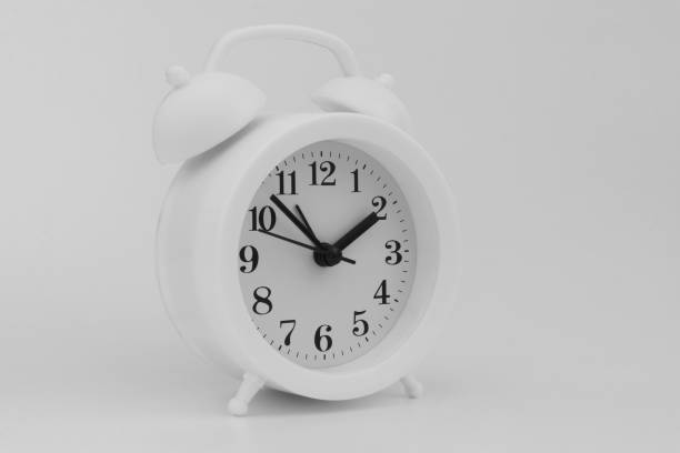 istock Round alarm clock on gray background 1323446944