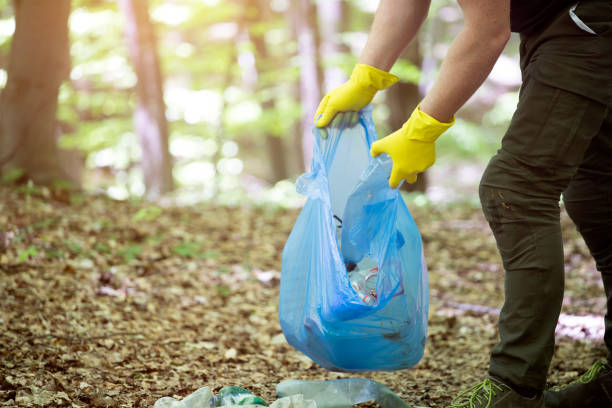 istock Volunteer collecting garbage in the woods. 1323447680