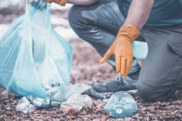 istock Volunteer collecting garbage in the woods. 1323448566