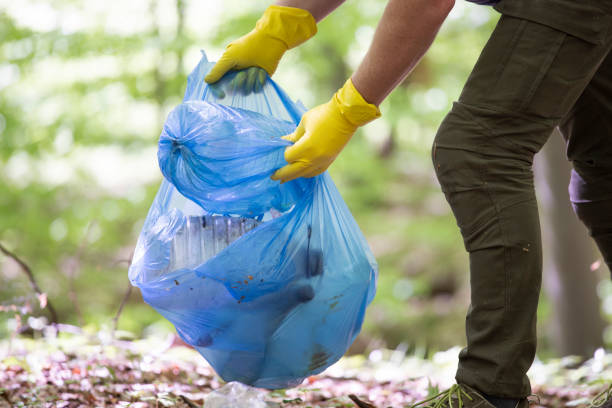 istock Volunteer collecting garbage in the woods. 1323449761