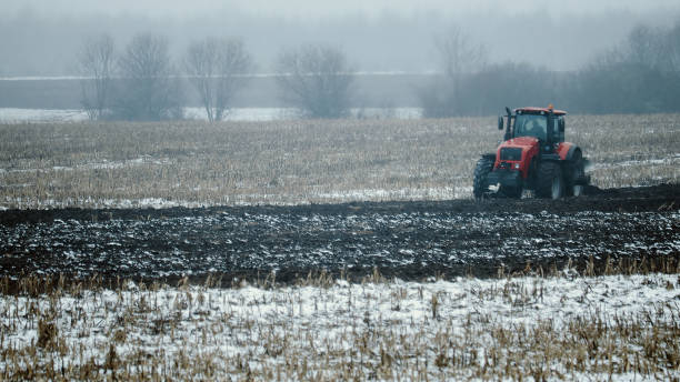 istock Tractor plows snow-covered farmland in spring 1323451067