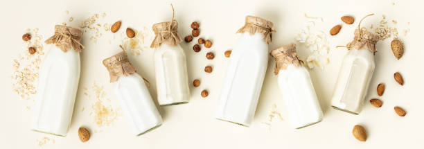 istock Non dairy plant based milk in bottles and ingredients on light background. Alternative lactose free milk substitute, flat lay 1323454882