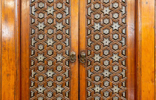 Closeup of wooden arabesque decorations tongue and groove assembled, inlaid with ivory and ebony, on door of Minbar of Imam Al Shafii public Mosque, Old Cairo, Egypt