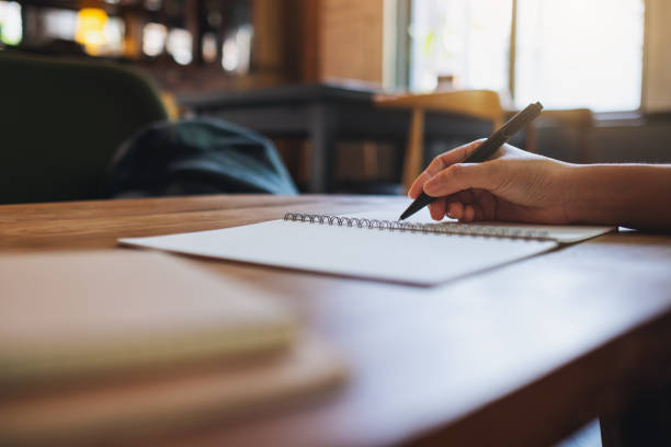 istock a woman writing on a blank notebook on the table 1323456654