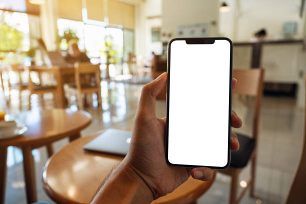 istock a man holding black mobile phone with blank white screen in cafe 1323456727