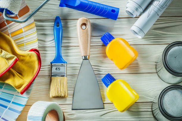 istock brush and spatulla with many other construction tools on white wooden boards 1323458296