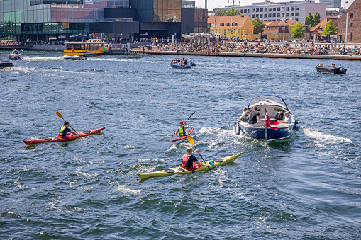 Group of kayaks crossing the harbor in central Copenhagen. The increasing traffic of leisure boats has made necessary to make this kind of activities with a high degree of carefulness