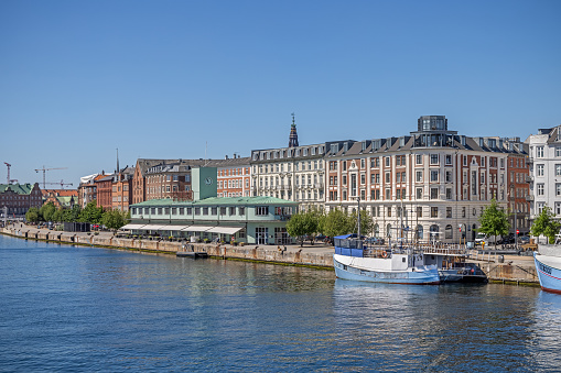 View down Copenhagen harbor to old residential buildings. The low green building is the old ferry terminal servicing the line to Malmoe in Sweden before the construction of the Oresund Bridge