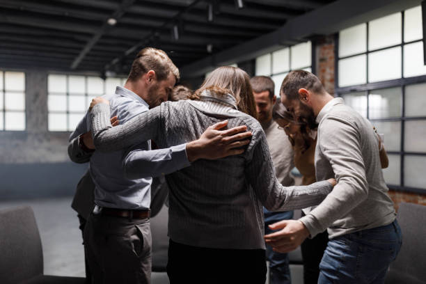 istock Happy entrepreneurs embracing at group therapy. 1323460092