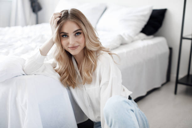 istock A woman sitting on a light floor alone in a bedroom. 1323460434