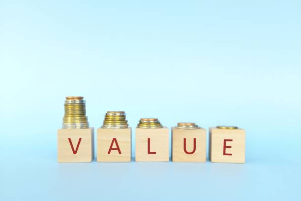 istock Price devaluation or value depreciation concept. Decreasing stack of coins in wooden blocks with word value. 1323462000