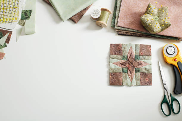 Patchwork block, stacks of fabrics, fabric scraps, sewing and quilting accessories