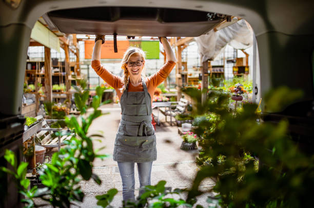 garden center worker transporting plants - transportation freight transportation messenger delivering imagens e fotografias de stock