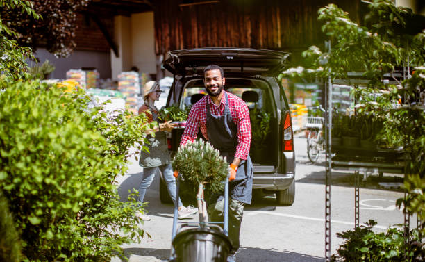 istock Garden center worker transporting plants 1323462414