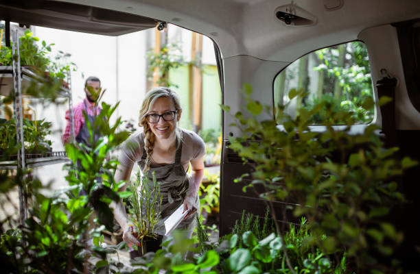 работники садового центра, перевозящие растения - высаживать средство передвижения стоковые фото и изображения